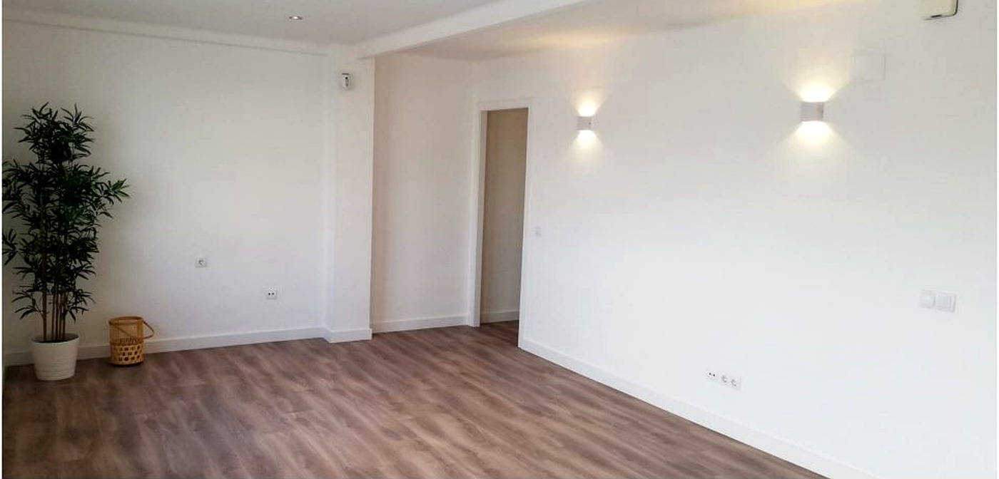 Apartamento después de renovación, con pisos nuevos, paredes blancas e iluminación instalada